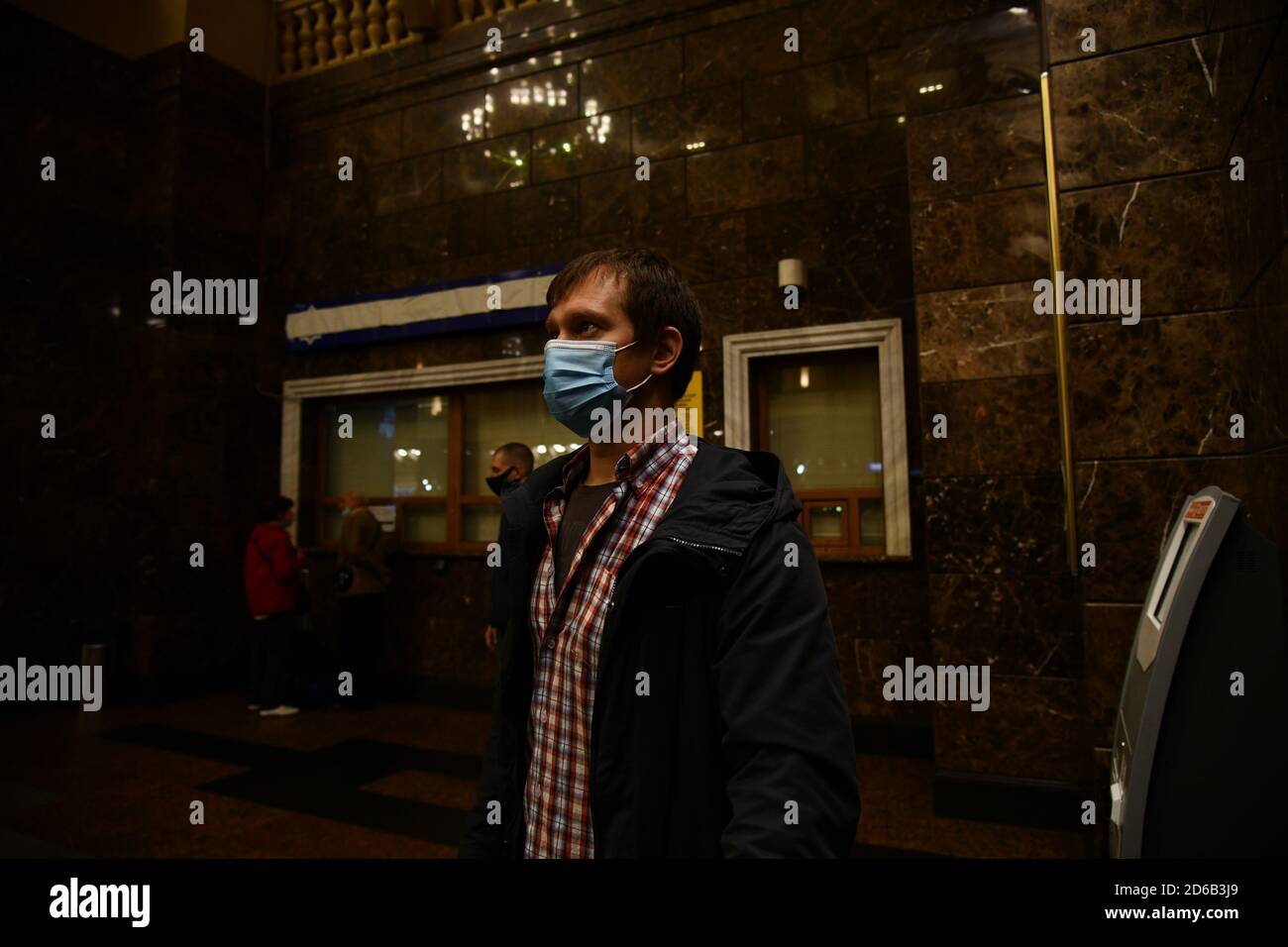 I passeggeri delle stazioni ferroviarie e degli aeroporti aderiscono alle restrizioni della pandemia COVID-19: Indossano maschere e osservano le distanze sociali. Foto Stock