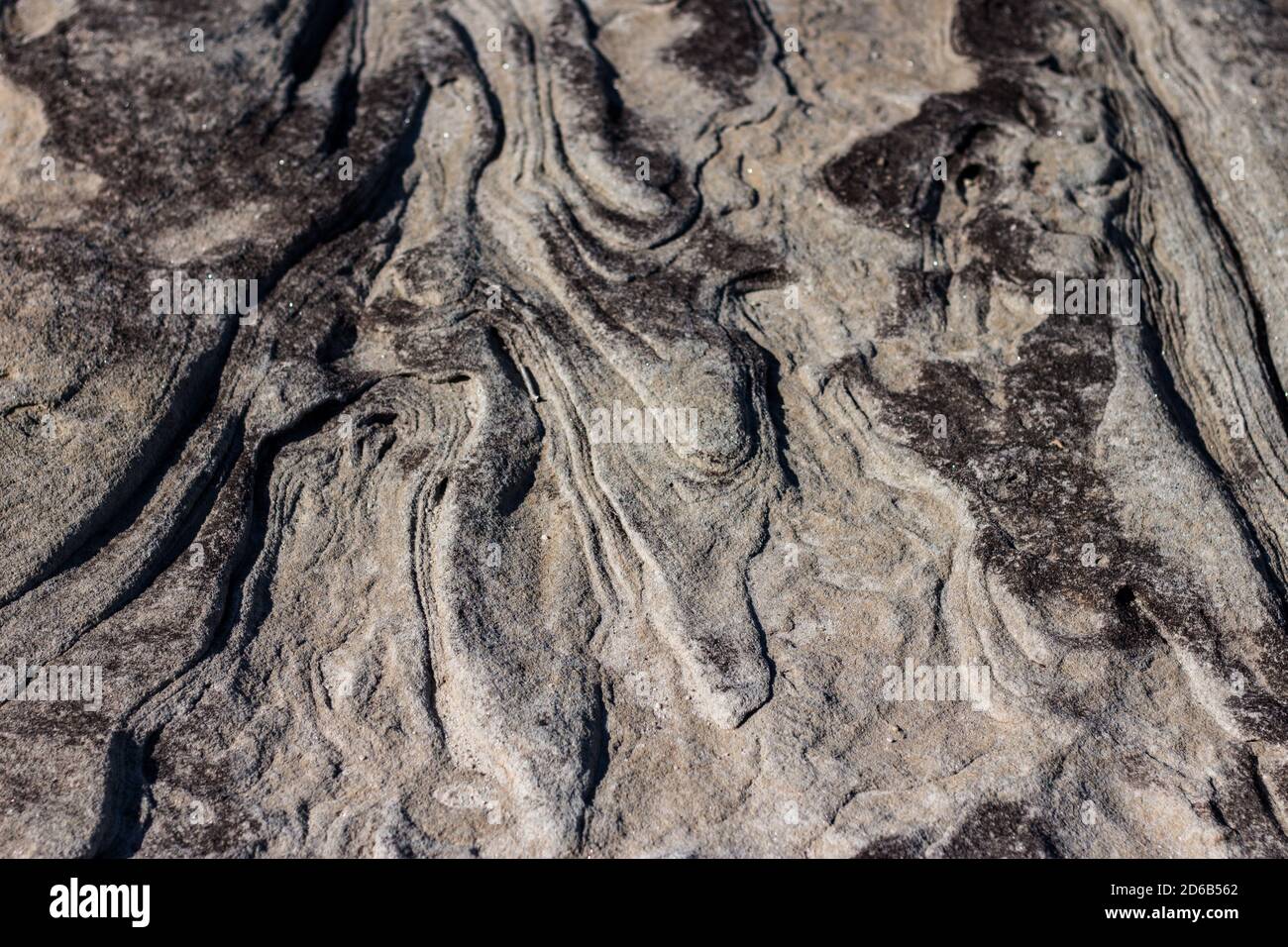 Superficie ruvida ondulata naturale in pietra arenaria ideale come sfondo Foto Stock