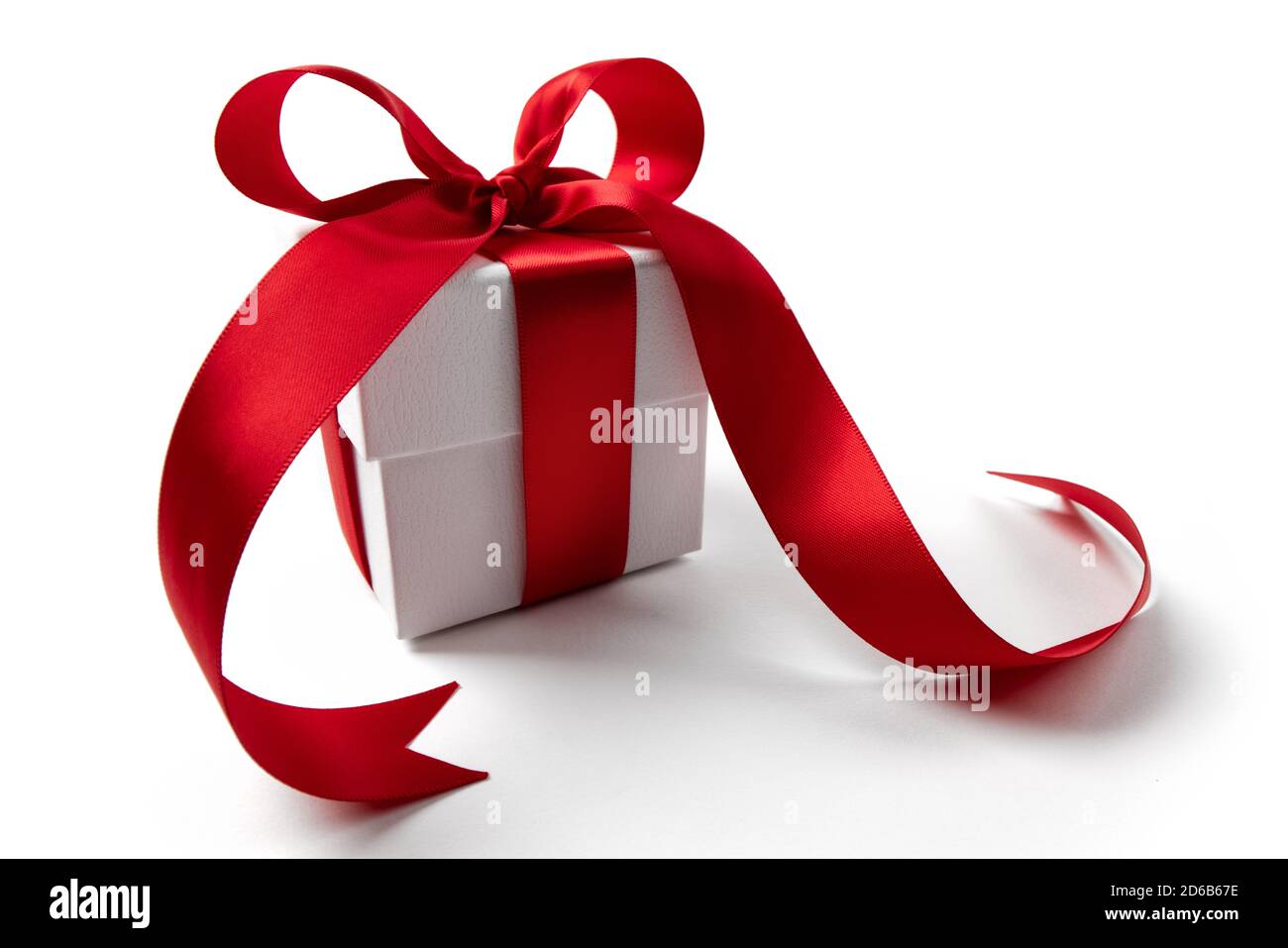 Scatola regalo bianca con un nastro rosso bow, isolato su bianco Foto Stock