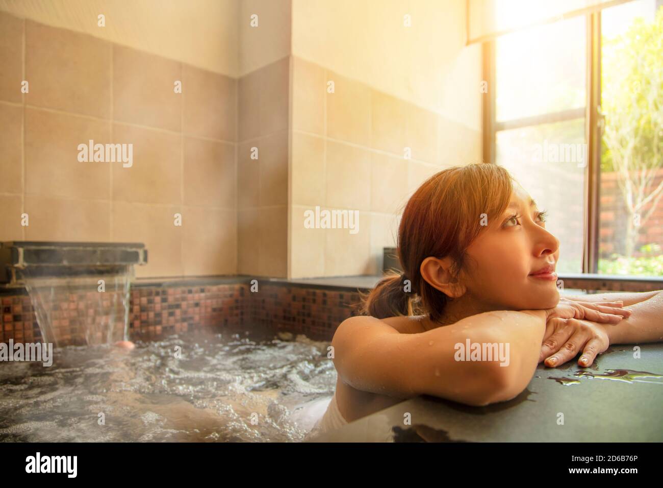 Bella giovane donna asiatica che si rilassa in una sorgente calda Foto Stock