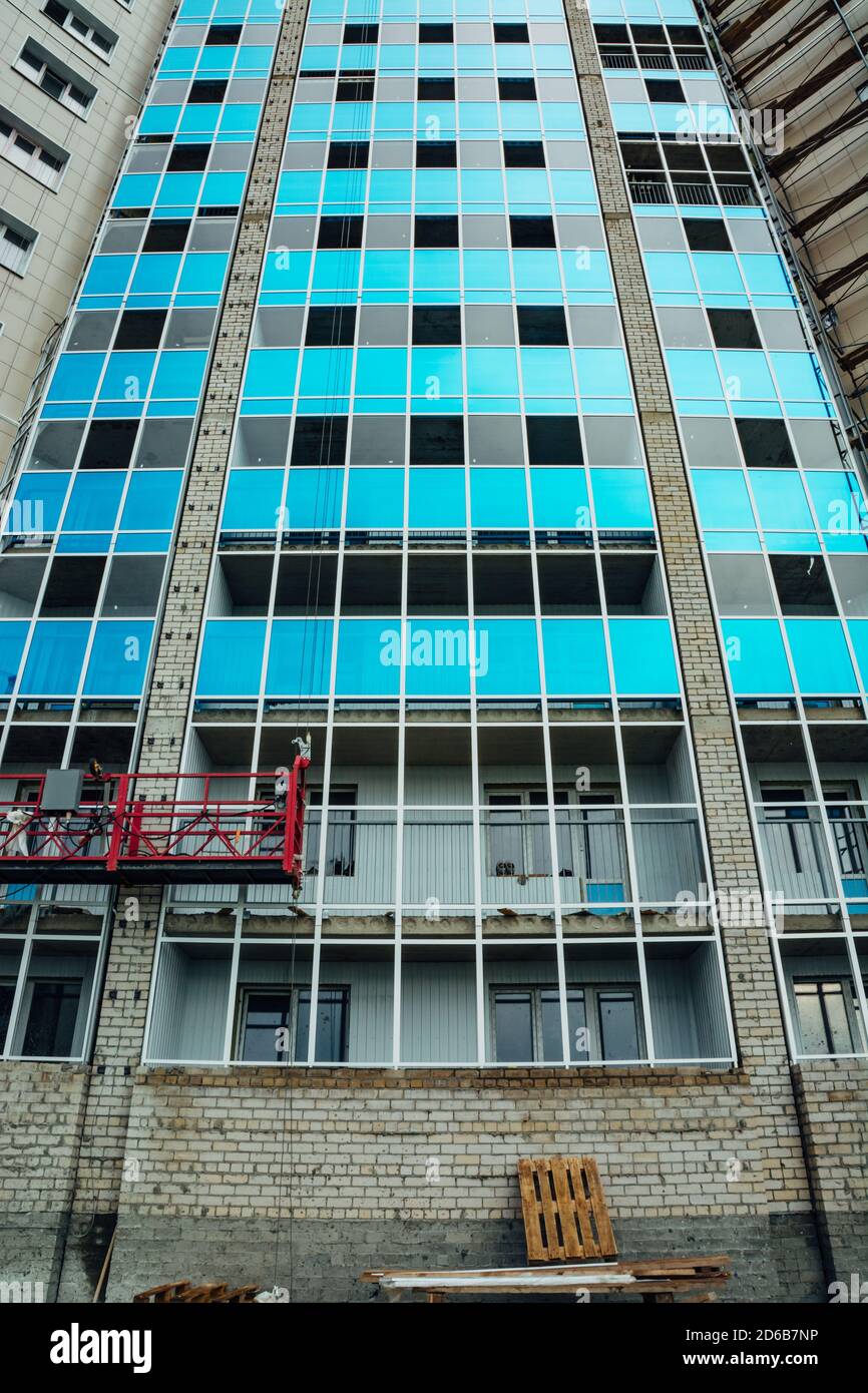 Costruzione di un moderno edificio residenziale a più piani. I balconi in vetro sono blu. Foto Stock
