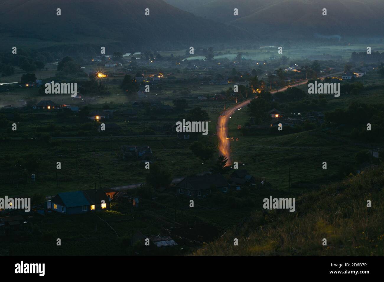 Il villaggio in montagna di notte da una vista a volo d'uccello. Il modo Latteo delle macchine. Altai. Foto Stock