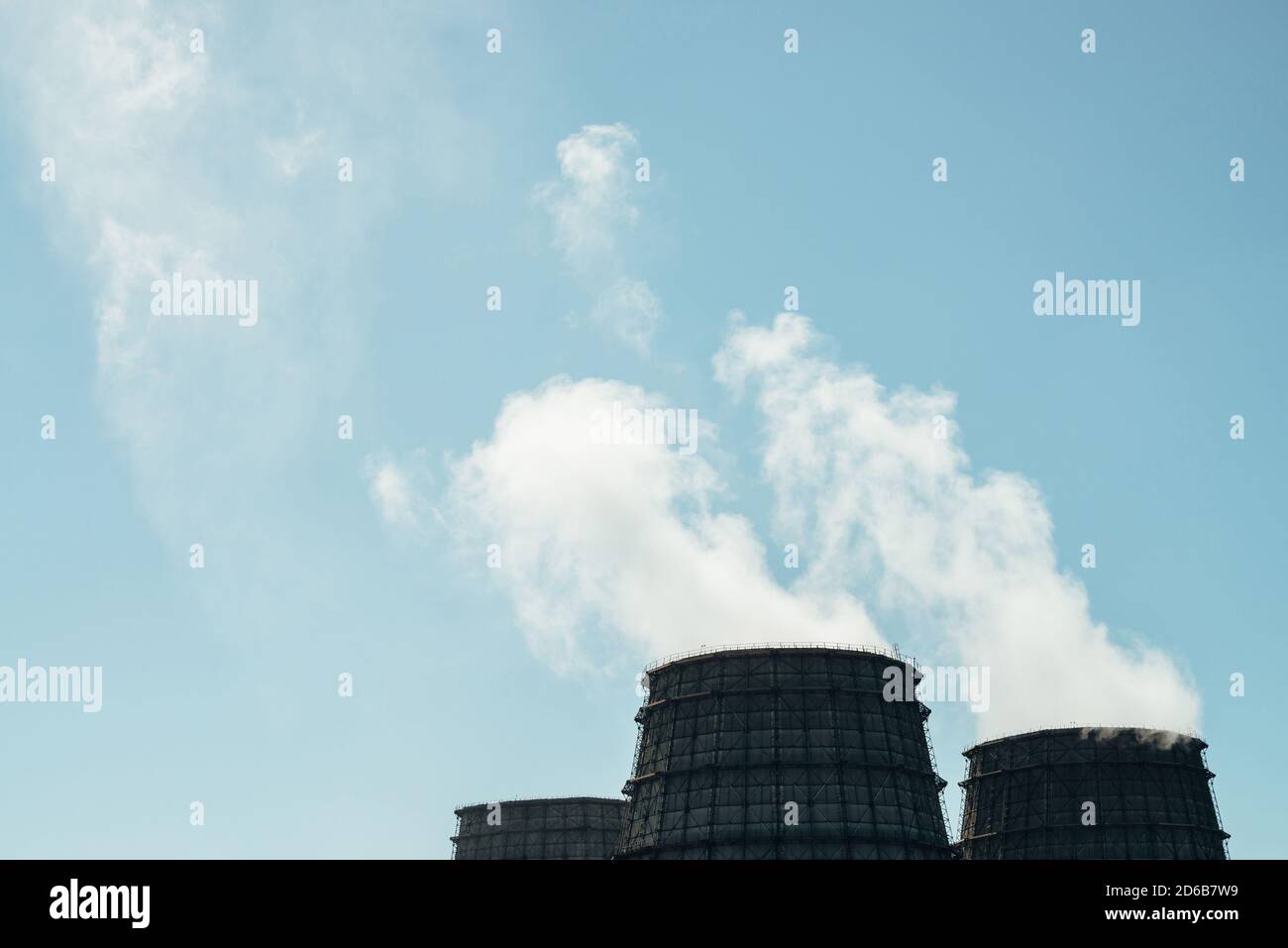 Tre grandi torri di CHPP primo piano. Vapore bianco da un ampio tubo di CHP su cielo blu. Immagine di sfondo industriale di TPP con spazio di copia. Tubi enormi del Foto Stock