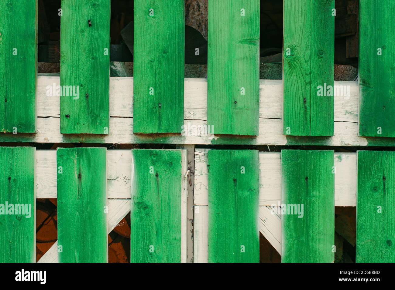 Frammento di fienile cancelli da vivido verde tavole lunghe primo piano. Stoccaggio di legna da ardere in capanna dietro porte di legno con spazio copia. Stile di vita rustico. Textu Foto Stock