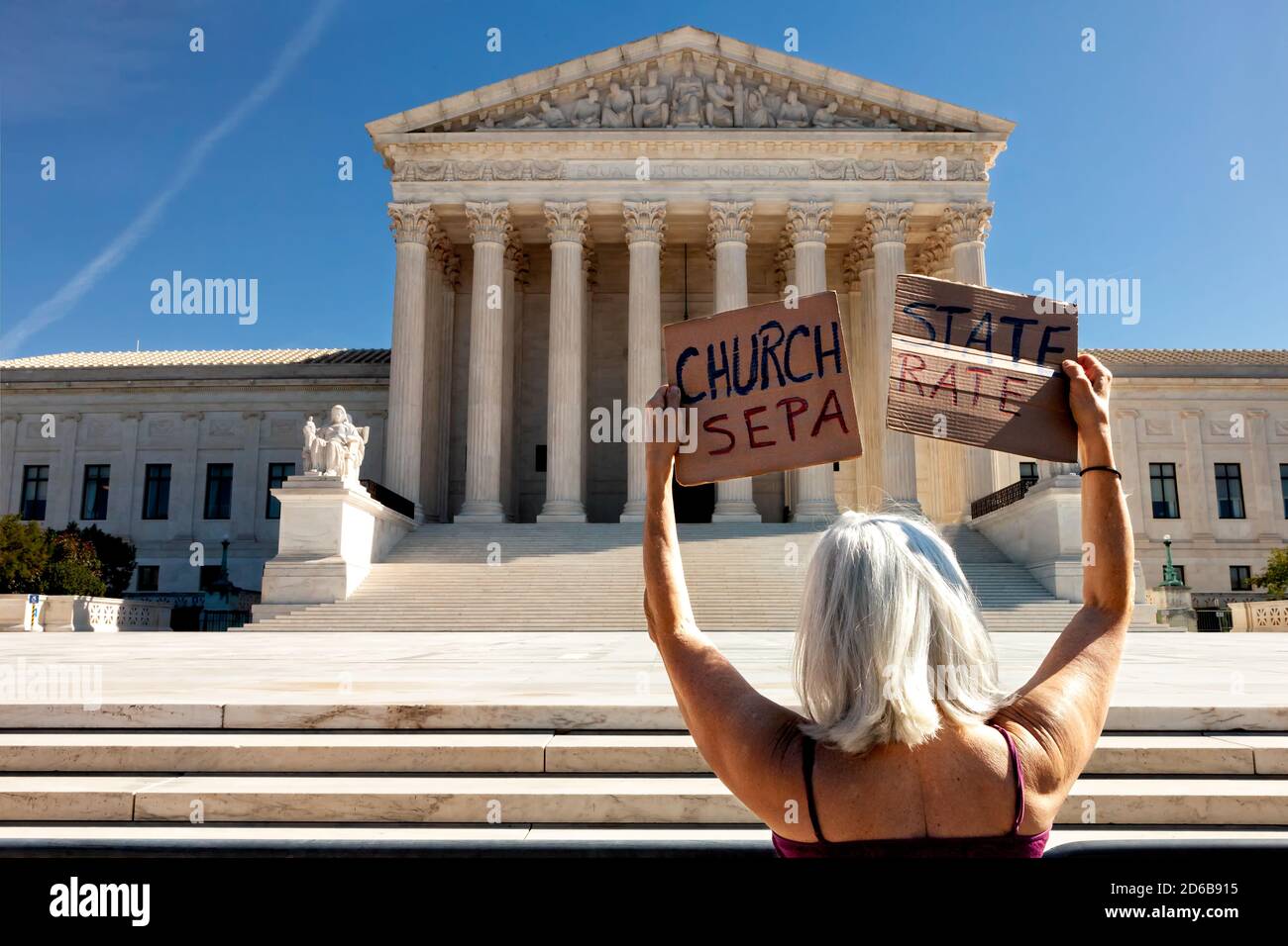 Washington, DC, USA, 15 ottobre 2020. Nella foto: Una donna tiene due metà di un segno che sostiene la separazione della chiesa e dello stato durante la discesa delle Handmaids sulla protesta della Corte Suprema detenuta da Rifiuta fascismo DC. Per l'evento, le donne vestite come schiere in capes rossi dalla pale della Sirenetta e si sono levate in piedi davanti all'edificio della Corte Suprema per protestare contro la nomina di Amy Coney Barrett e le politiche fasciste dell'amministrazione Trump. La protesta continua a rifiutare la richiesta del fascismo di rimuovere immediatamente Donald Trump e Mike Pence dal suo ufficio. Credit: Alison C Bailey/Alamy Live News Foto Stock