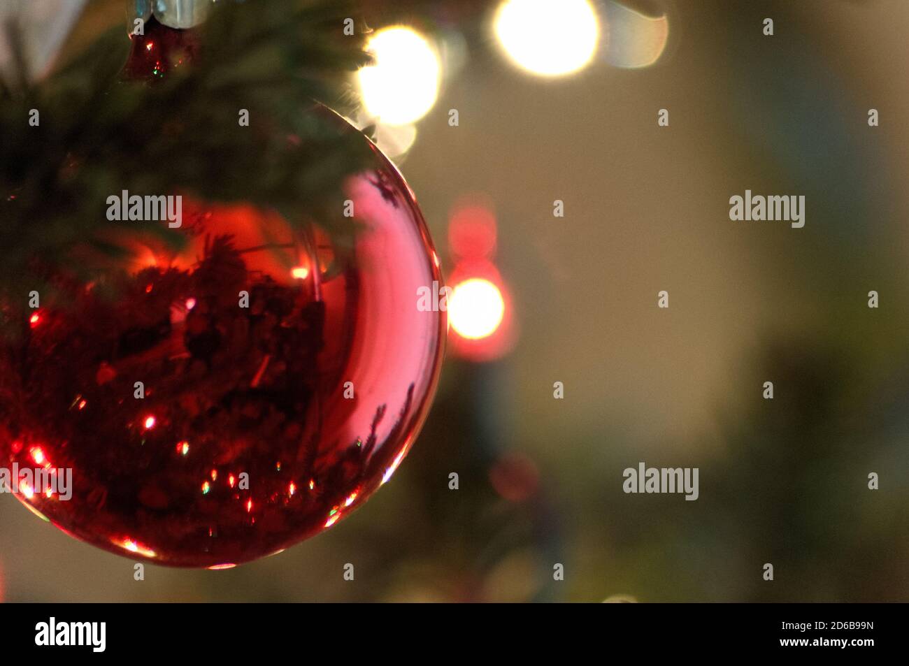 Primo piano di una palla o bulbo di Natale rosso, a sinistra con spazio per la copia Foto Stock