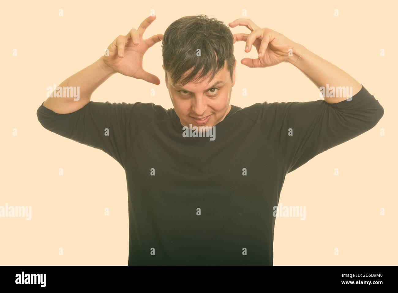 Studio shot del pazzo uomo caucasico con entrambe le braccia sollevate Foto Stock