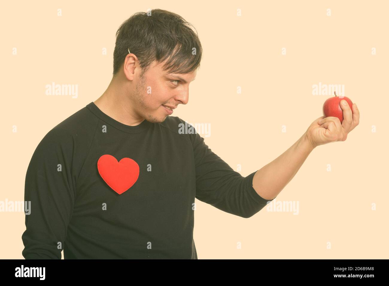 Vista profilo di uomo caucasico pazzo che tiene pronta mela rossa Per San Valentino Foto Stock