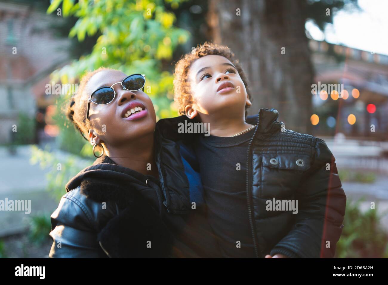 Ritratto di una madre afroamericana con suo figlio che si diverte all'aperto nel parco. Famiglia monoparentale. Foto Stock