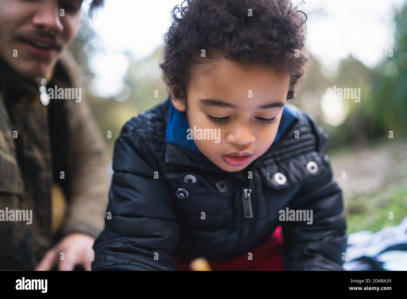 Ritratto di un ragazzo afro-americano che gioca e si diverte con suo padre all'aperto nel parco. Famiglia monoparentale. Foto Stock