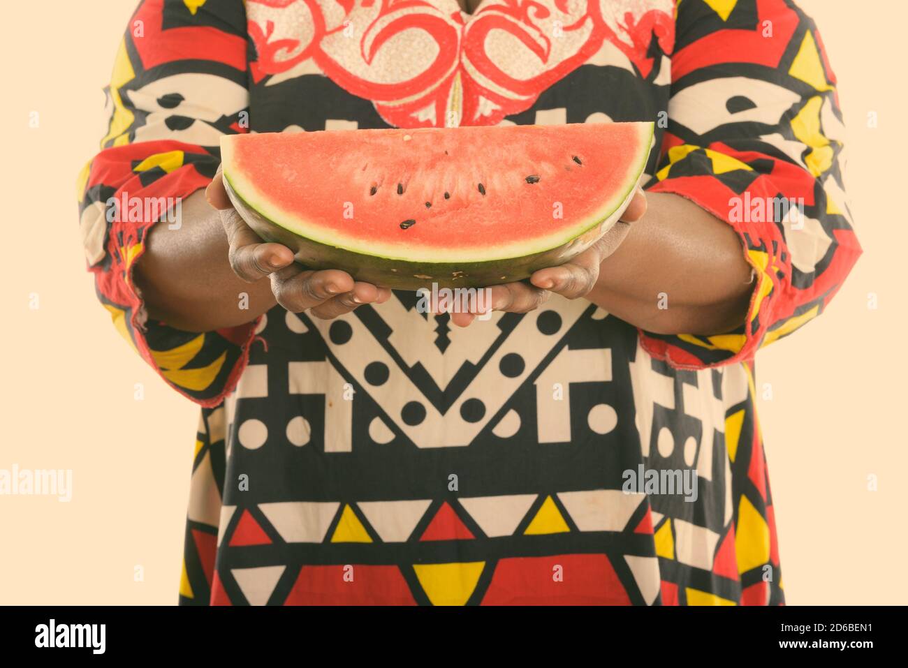 Studio shot di grasso nero donna africana che tiene fetta di cocomero Foto Stock