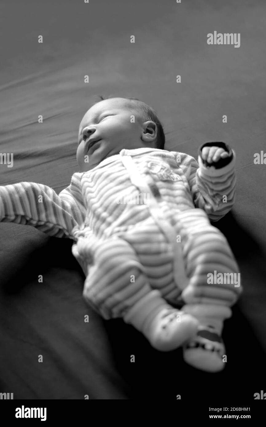 Closeup del bambino neonato carino sdraiato su sfondo nero Foto Stock