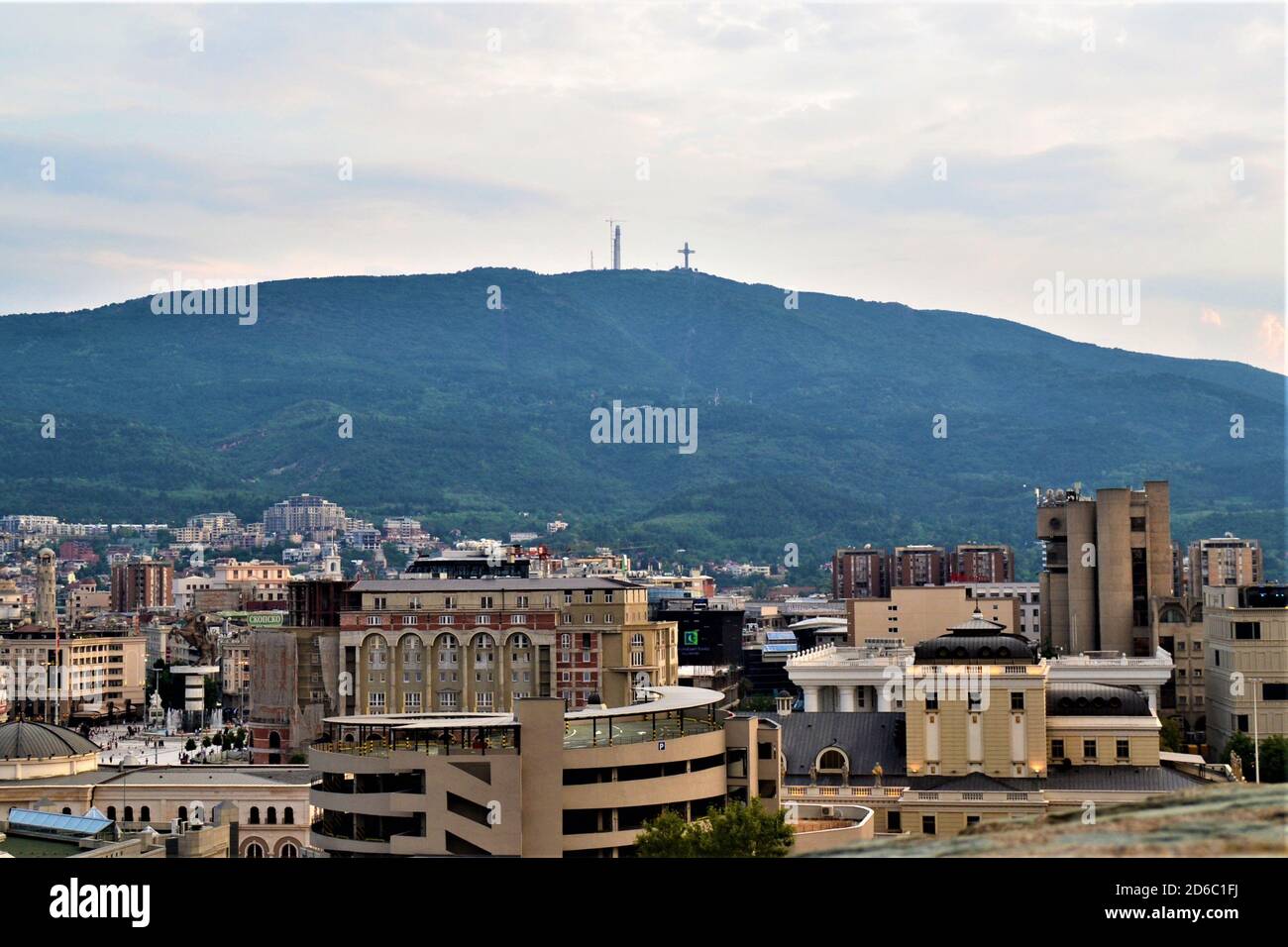 Skopje vista città dal castello ottomano. Edifici Skopje nel centro della città E enorme croce in Vodno montagna Foto Stock