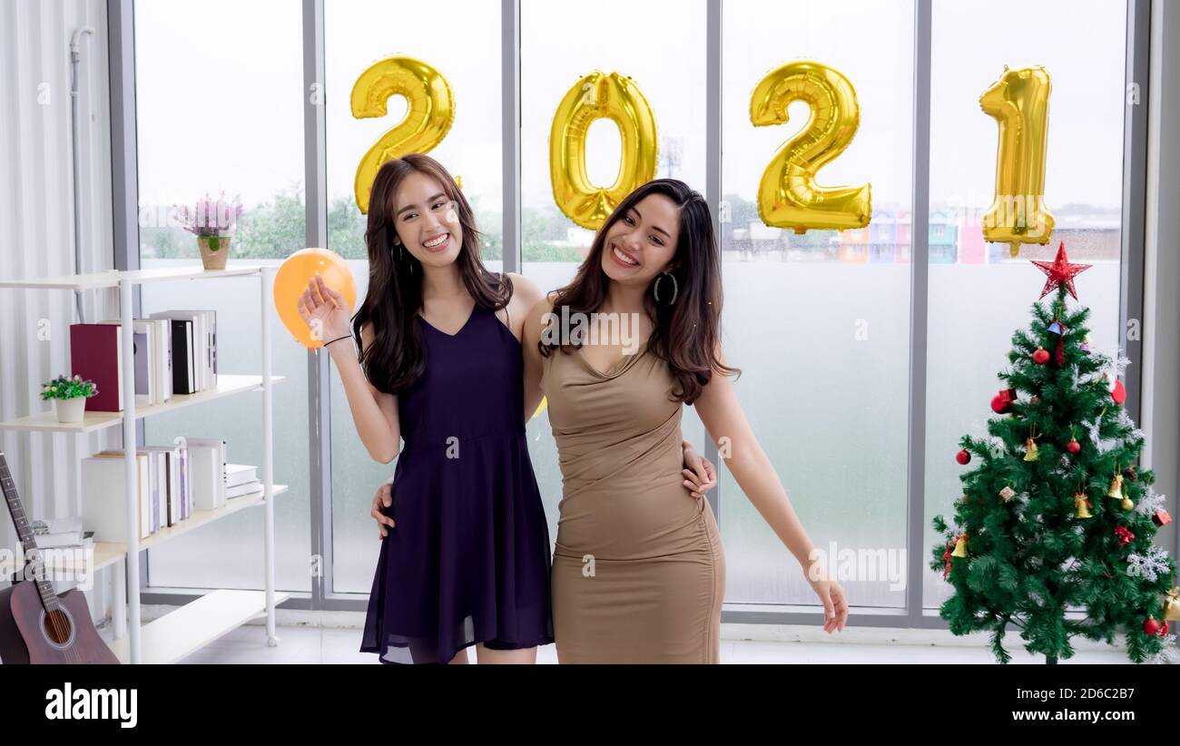 Ragazza asiatica che tiene numero 2021 palloncini a festa di Capodanno Foto Stock