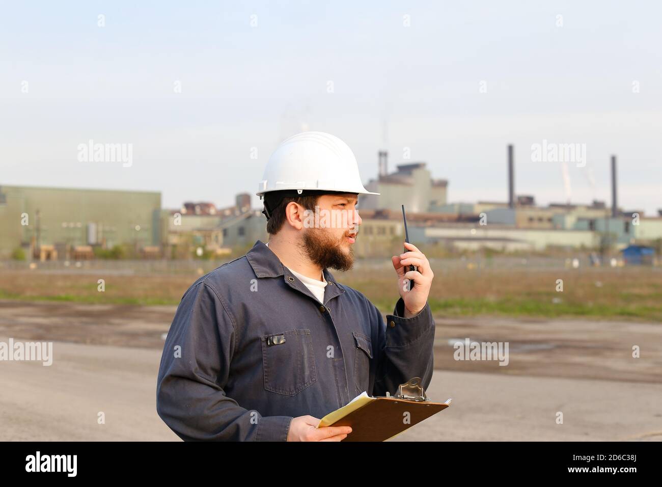 Ritratto di ingegnere maschile in piedi sul cantiere e tenendo carte. Foto Stock
