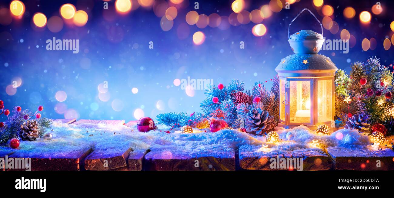 Lanterna di Natale decorativa con rami ornamentali e di abete e sfocata Luci Foto Stock