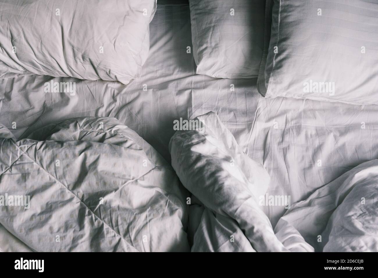 Letto non fatto. Lenzuola e cuscini dopo una notte di sonno. La vista dall'alto. Biancheria da letto bianca sporca Foto Stock