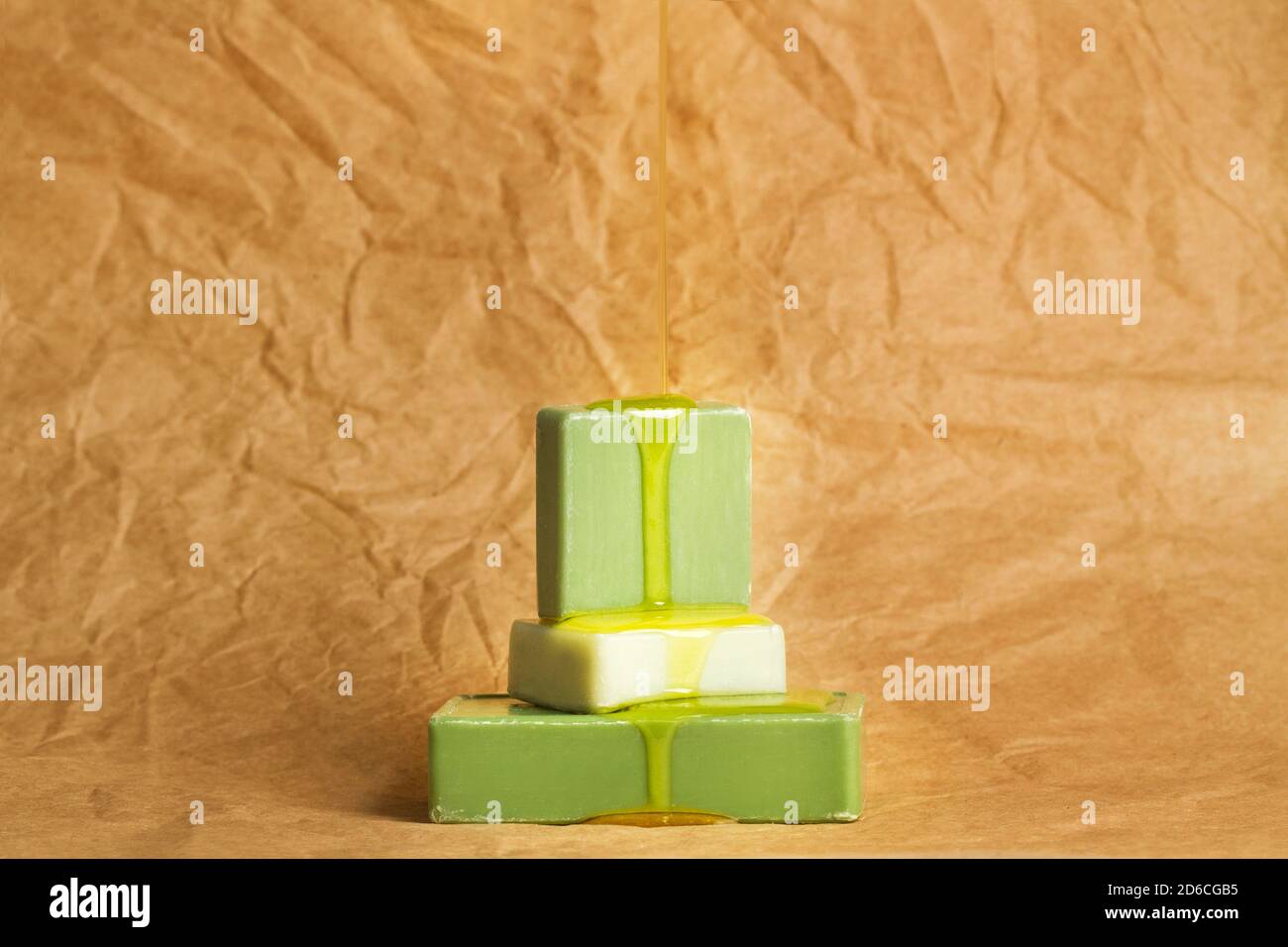 Gocciolando l'olio della pelle sulle saponette verdi su un grinzito carta marrone Foto Stock