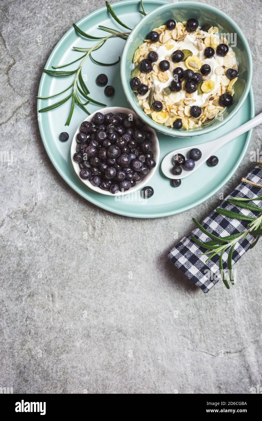 Granola di yogurt greco con mirtilli freschi su un tavolo di pietra, vista dall'alto con spazio per il testo. Cibo sano, snack o colazione. Foto Stock