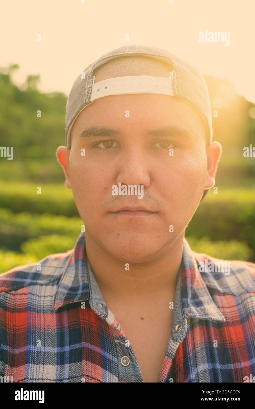 Giovane asiatico che indossa il cappello mentre si rilassa nel parco di Bangkok, Thailandia Foto Stock