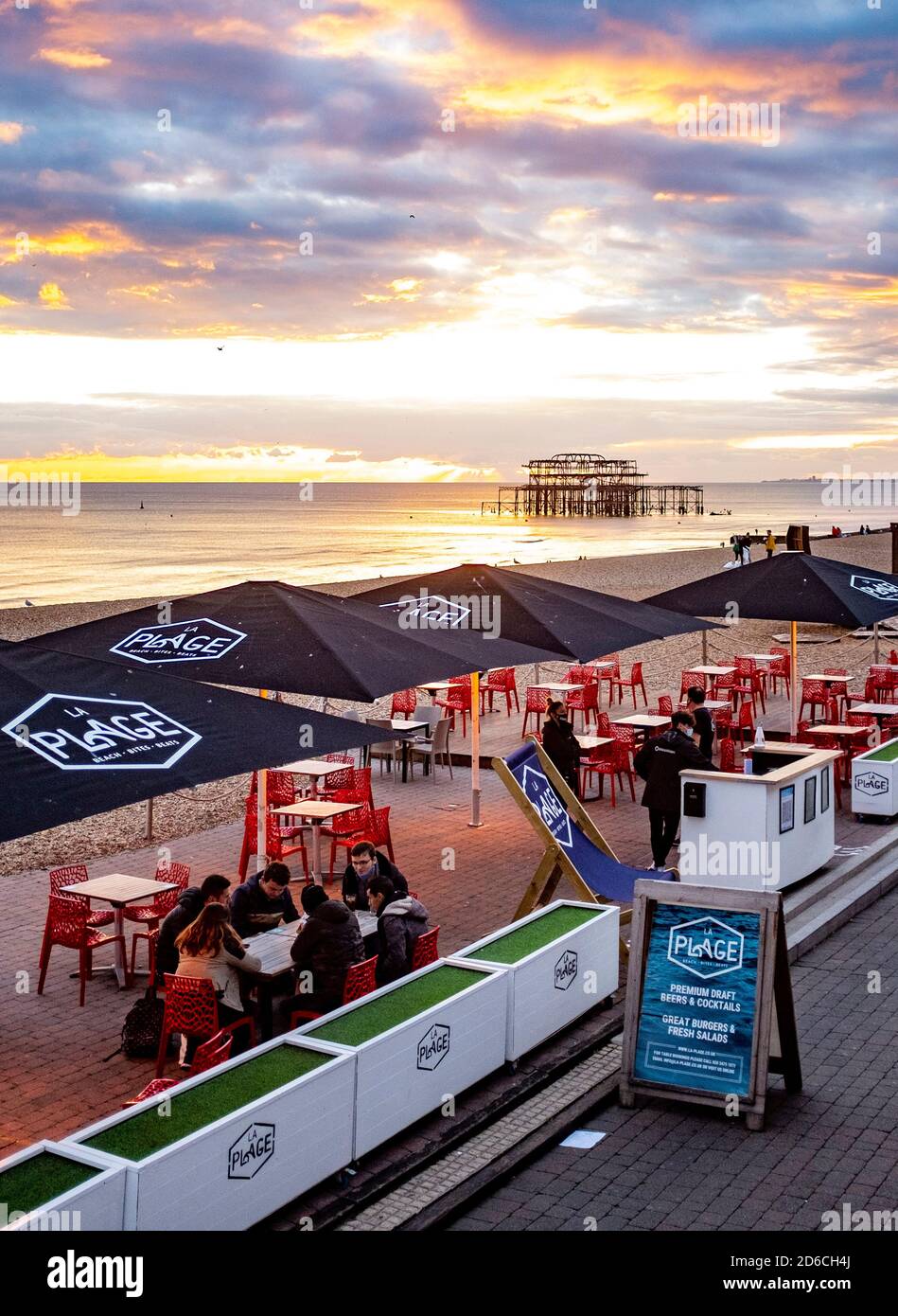 Brighton lungomare la Plage bar con persone che bevono al tramonto Crepuscolo Sussex Inghilterra UK Foto Stock
