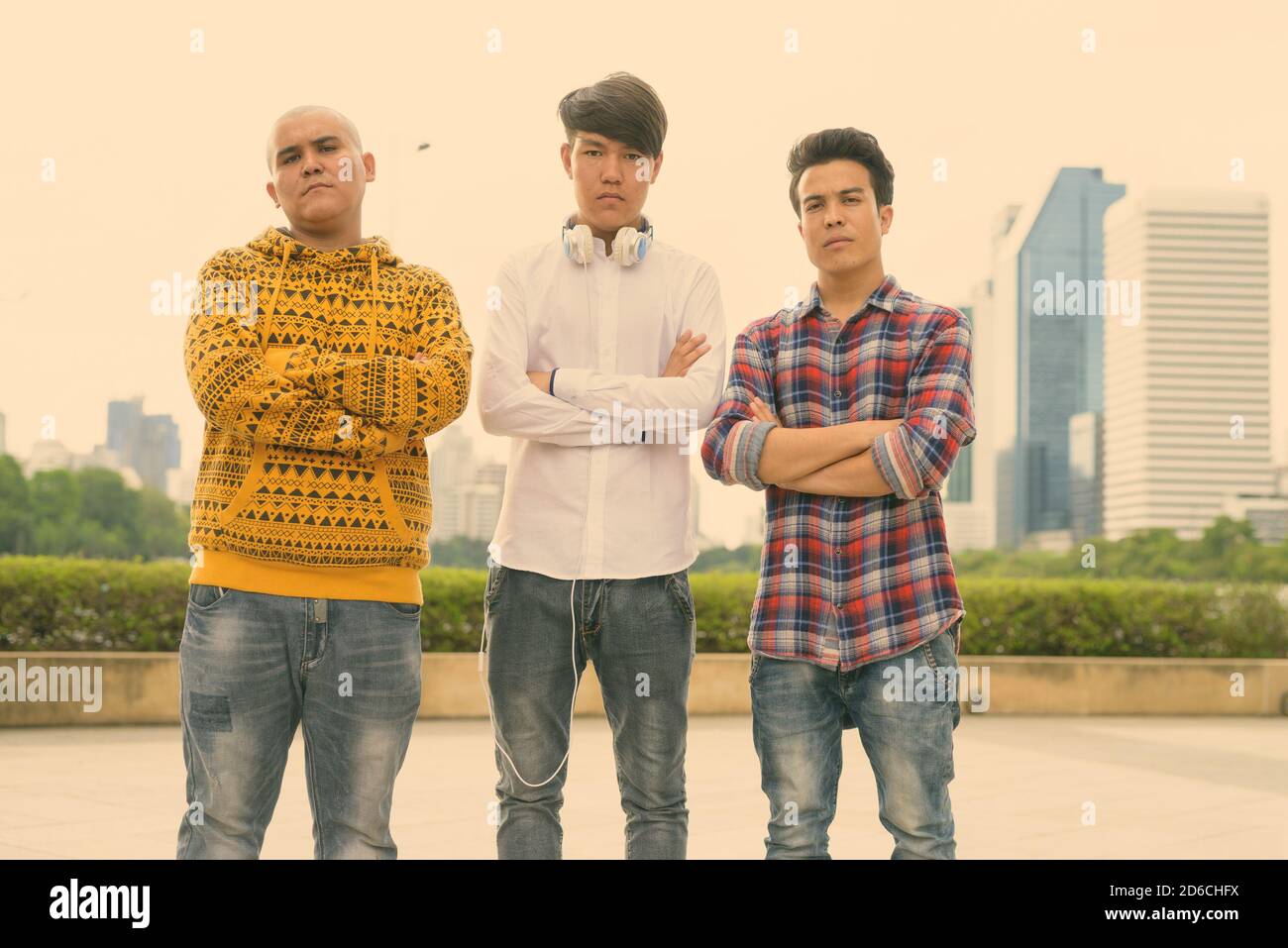 Tre giovani uomini asiatici di relax presso il parco insieme Foto Stock