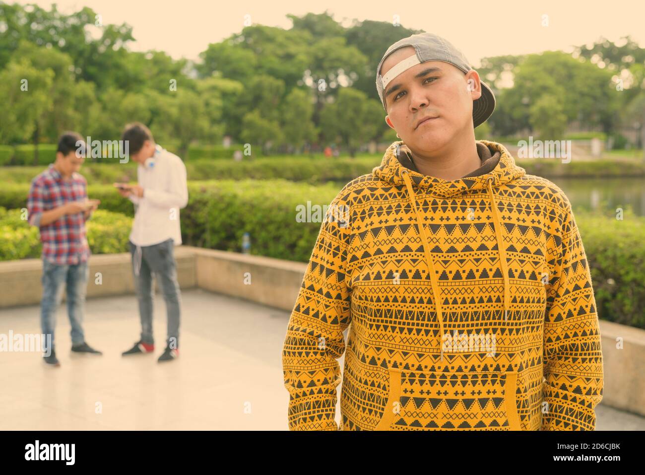 Tre giovani uomini asiatici di relax presso il parco insieme Foto Stock