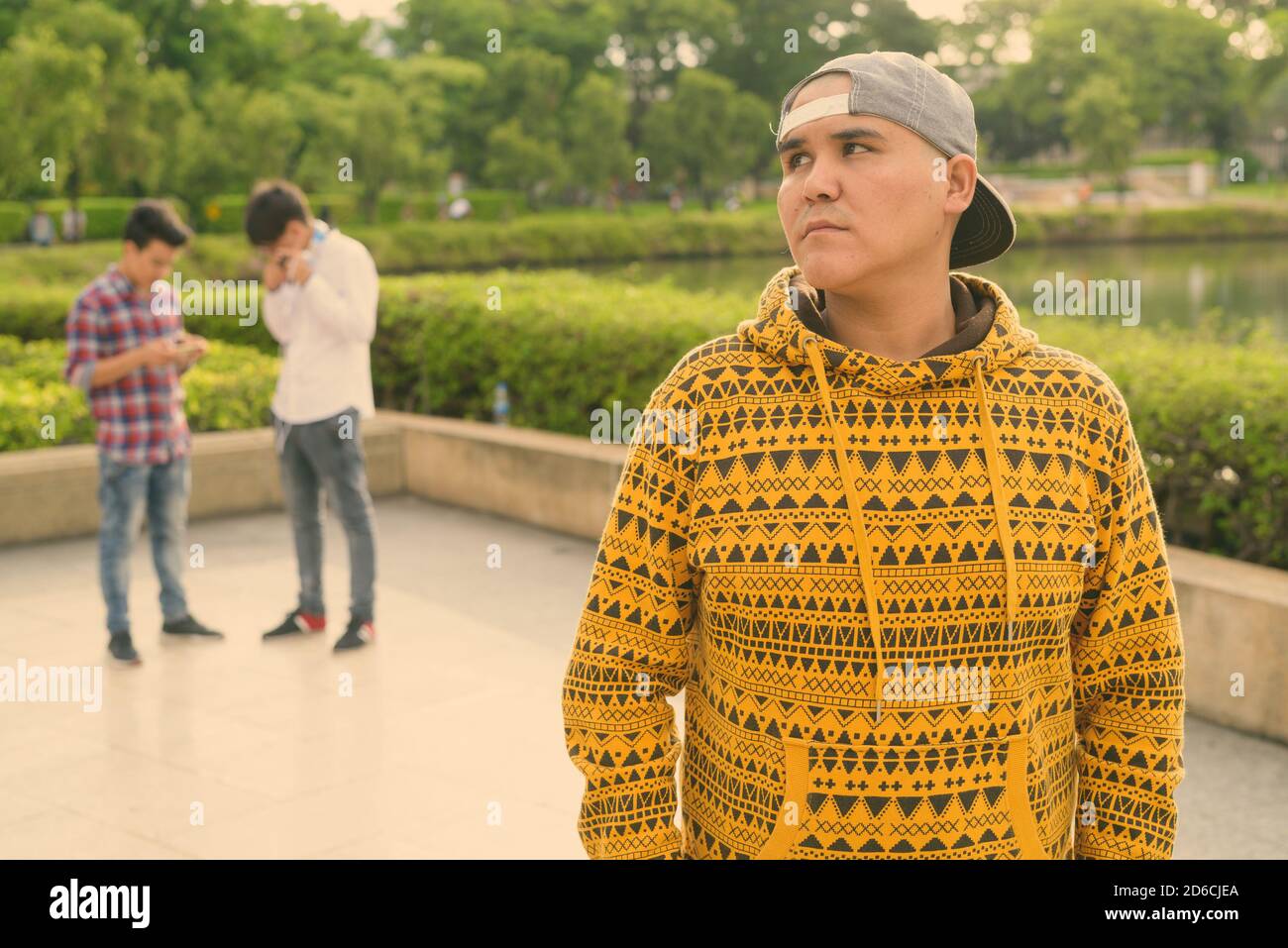 Tre giovani uomini asiatici di relax presso il parco insieme Foto Stock