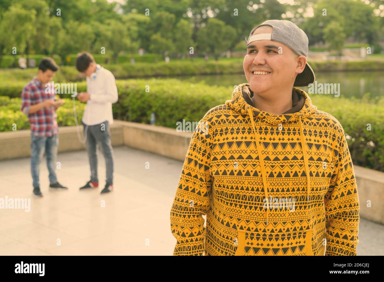 Tre giovani uomini asiatici di relax presso il parco insieme Foto Stock