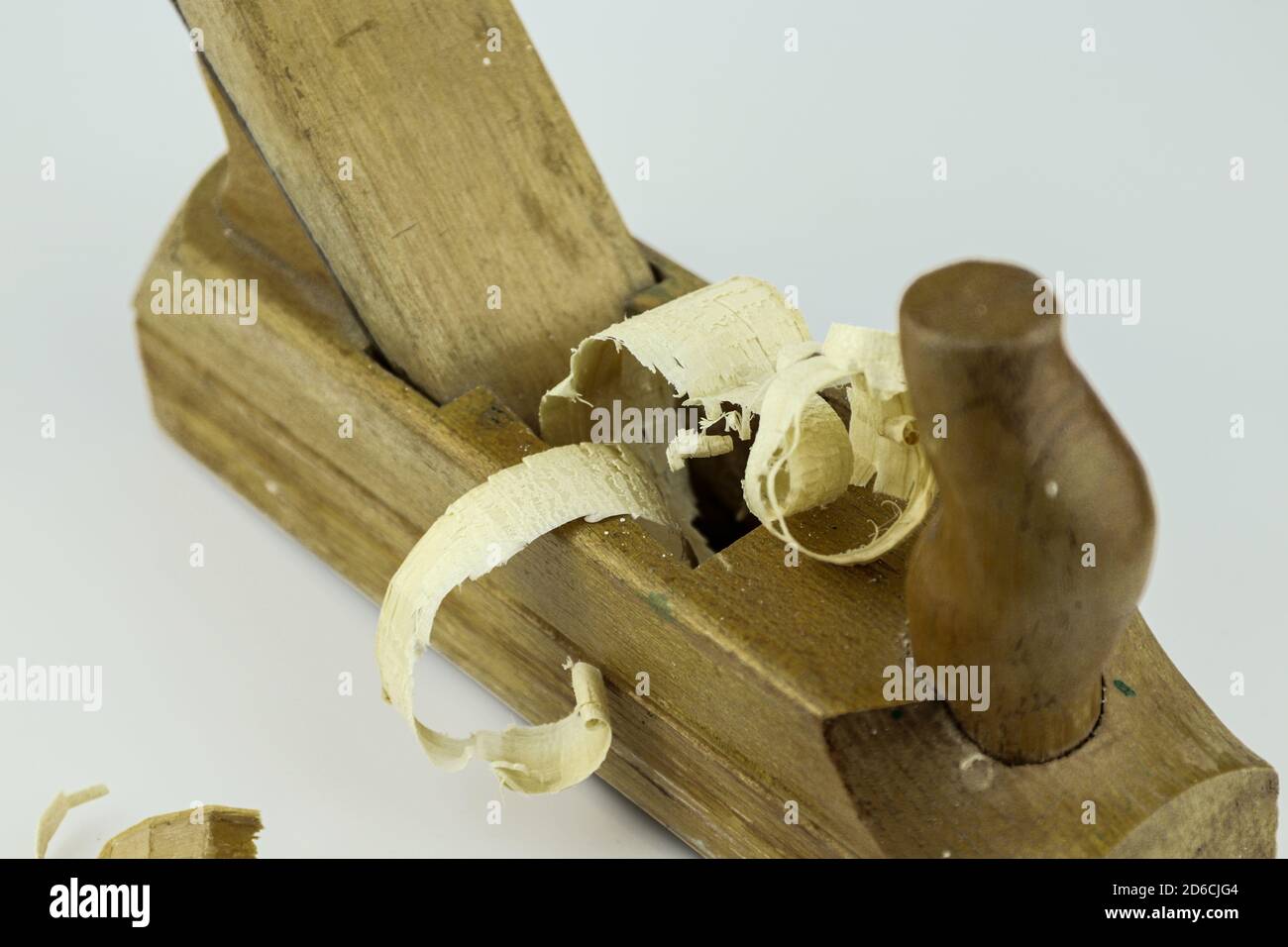 Particolare del tradizionale piano-martinetto in legno con segatura in legno isolata su sfondo bianco. Vecchio piano martinetto manuale e trucioli di legno. Foto Stock