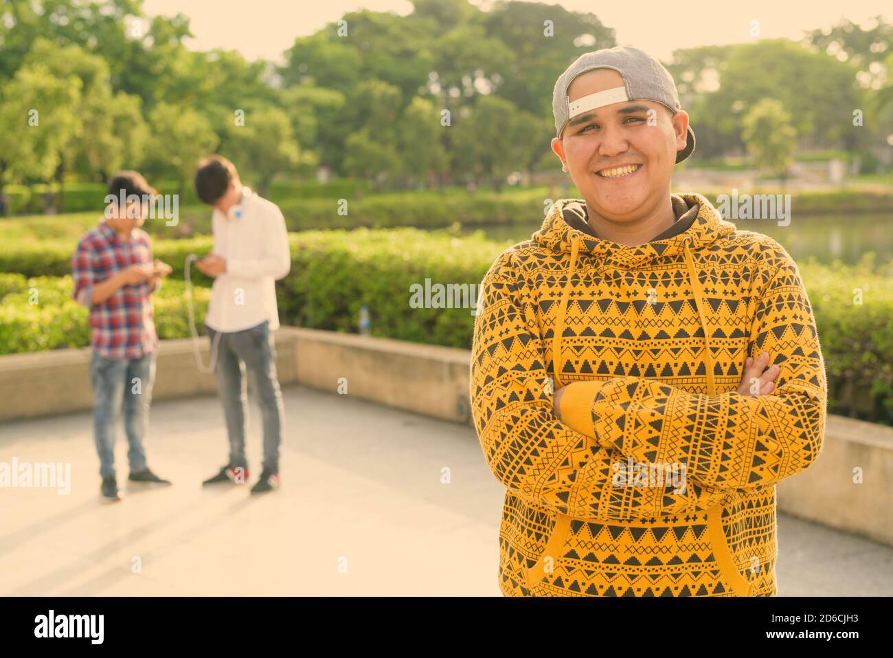 Tre giovani uomini asiatici di relax presso il parco insieme Foto Stock
