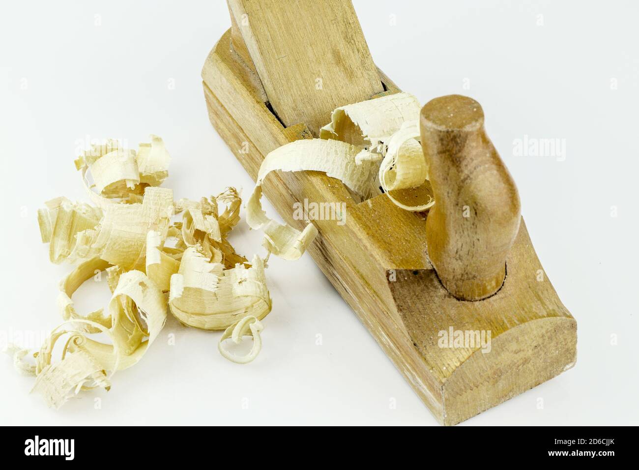 Particolare del tradizionale piano-martinetto in legno con segatura in legno isolata su sfondo bianco. Vecchio piano martinetto manuale e trucioli di legno. Foto Stock