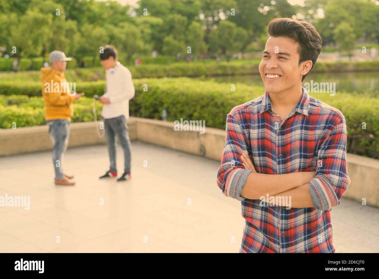 Tre giovani uomini asiatici di relax presso il parco insieme Foto Stock