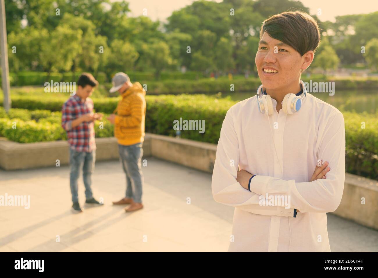 Tre giovani uomini asiatici di relax presso il parco insieme Foto Stock