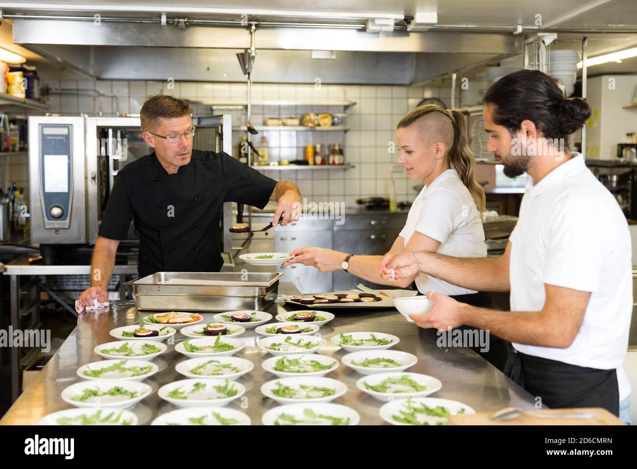 Le persone che lavorano nel ristorante cucina Foto Stock