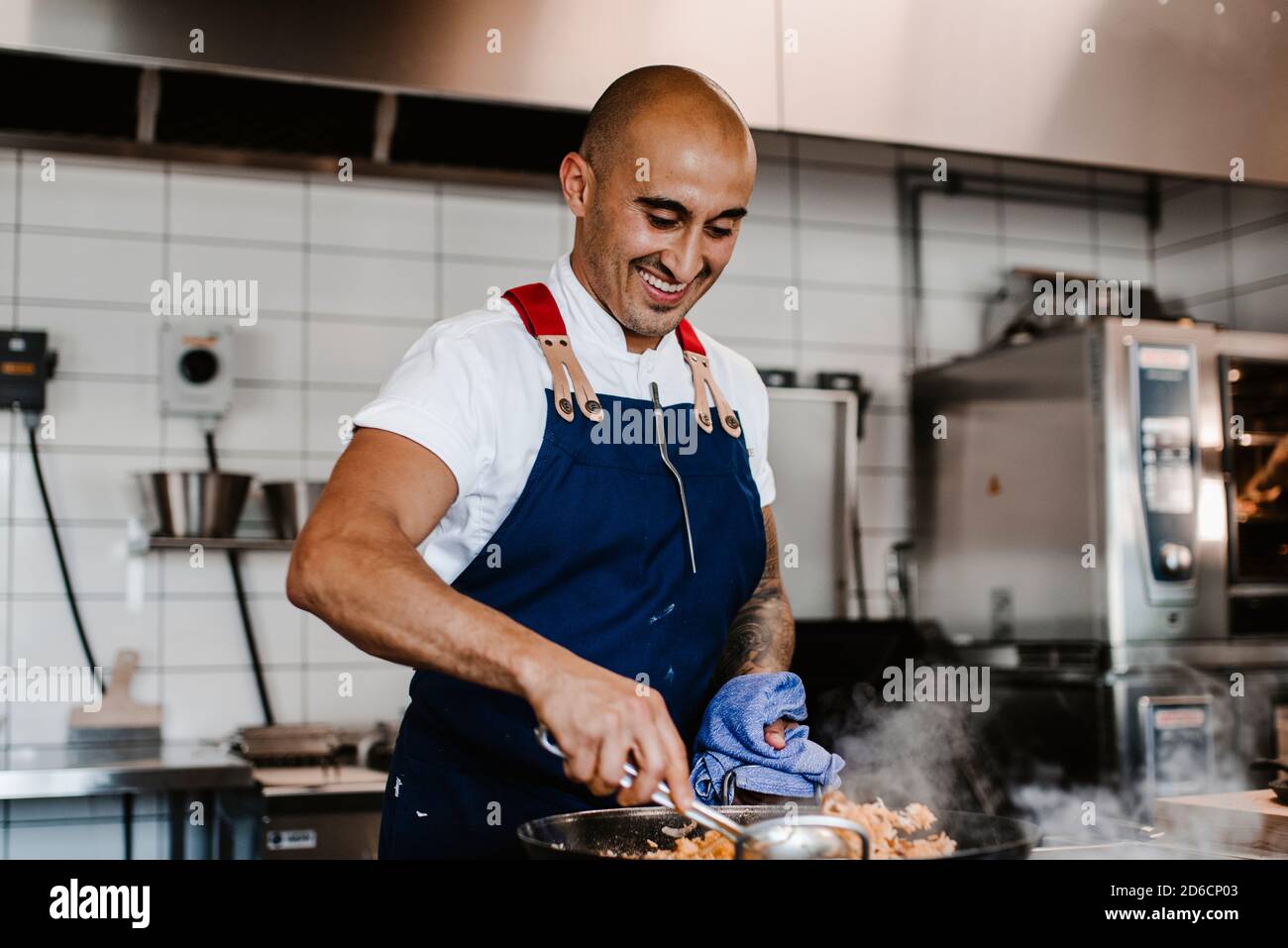 Chef sorridente che lavora in cucina Foto Stock