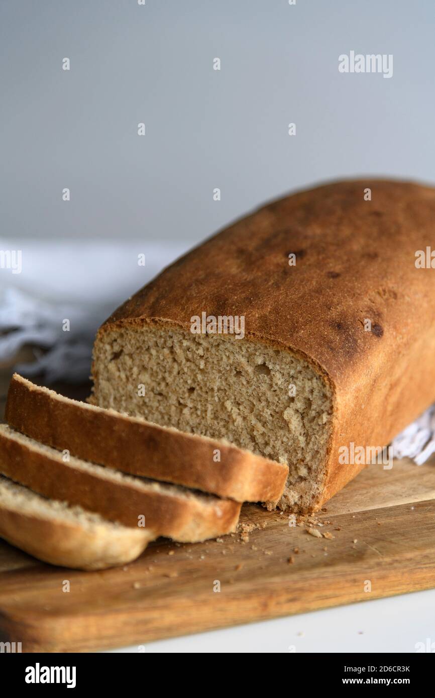 Pane fatto in casa a fette su un tagliere di legno Foto Stock