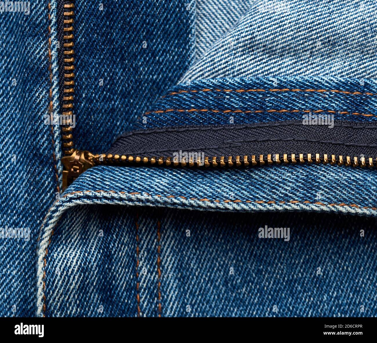 Ferro zipper giallo al volo su blue jeans, close up Foto Stock