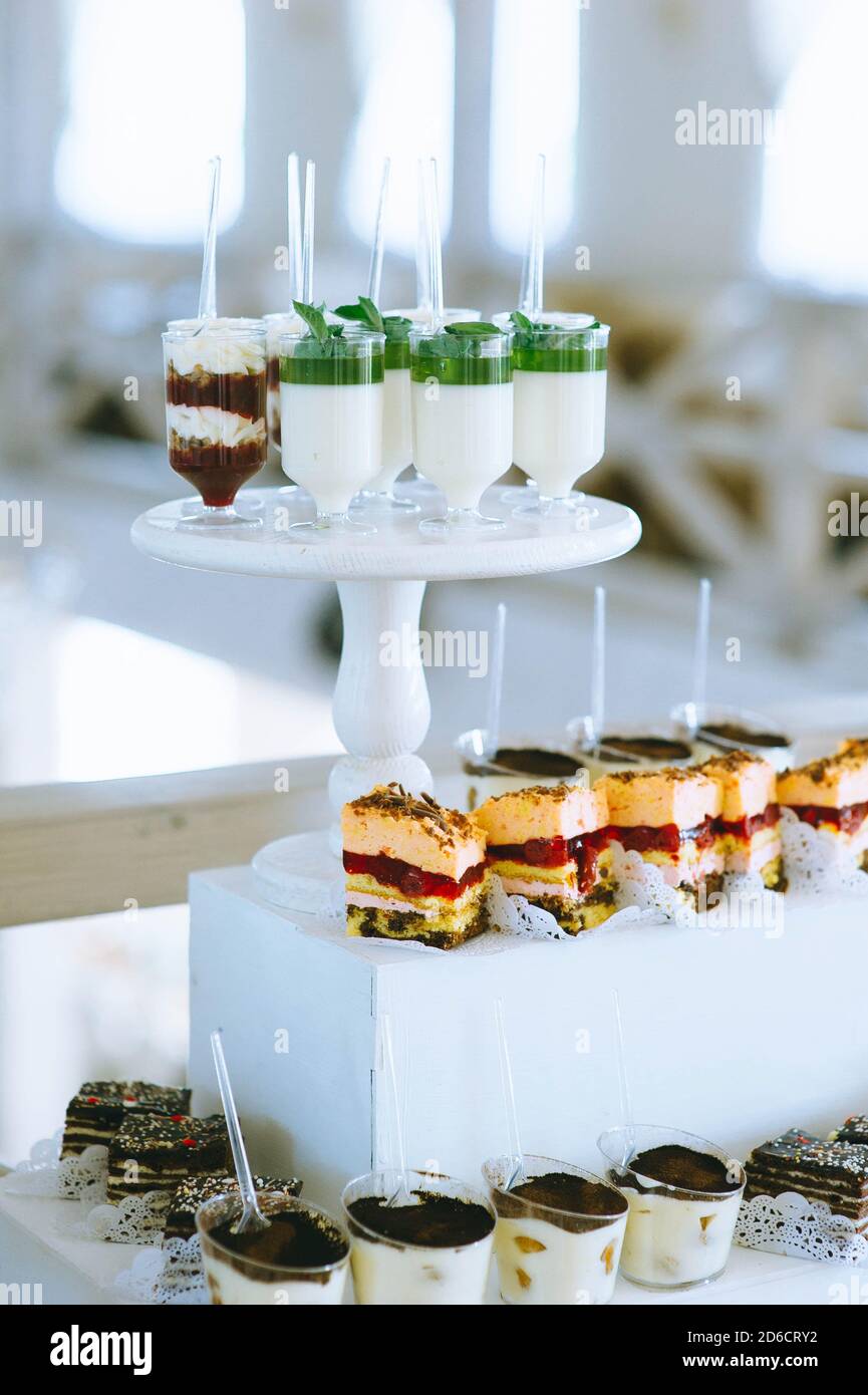 Wedding Candy bar con diversi colori vivaci cupcakes, macaroon, torte, gelatina e frutta. Foto Stock
