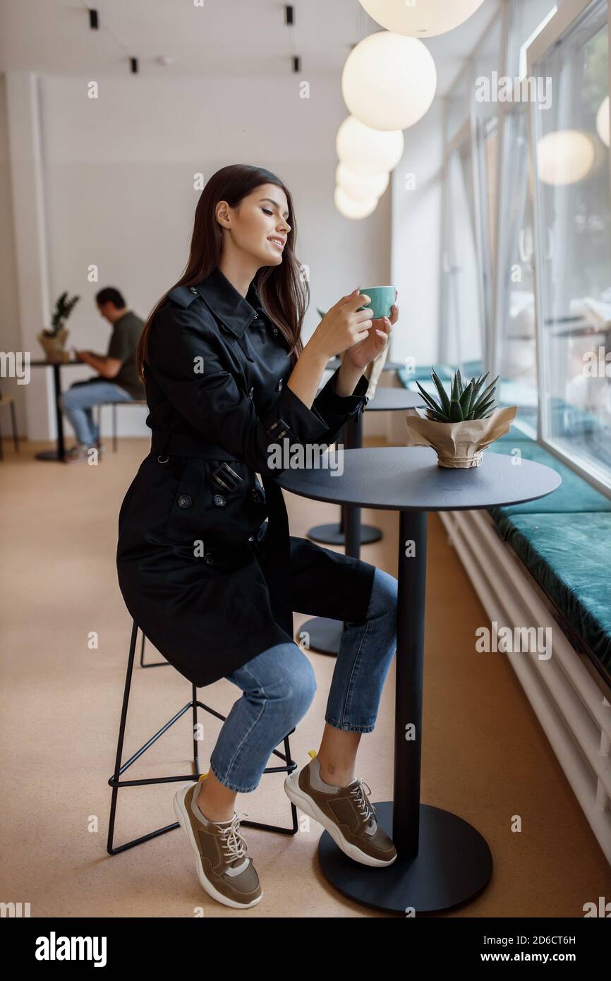 bella ragazza in una caffetteria con una tazza di caffè Foto Stock