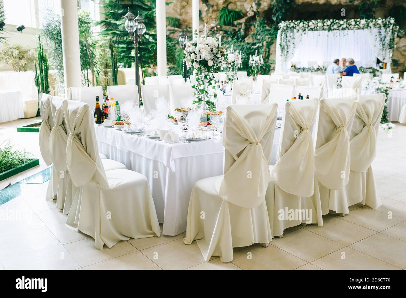 Il tavolo del matrimonio in colori pastello è decorato con fiori e un candelabro d'epoca. Foto Stock