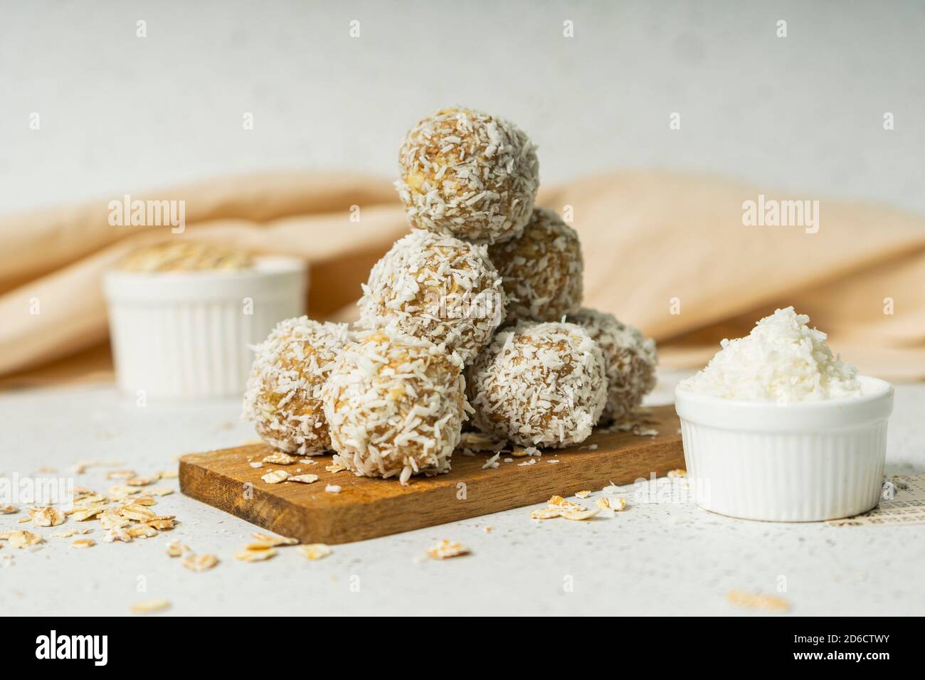 palle energetiche, fiocchi di avena interi e polvere di cocco, dolci a basso contenuto calorico, su sfondo chiaro Foto Stock