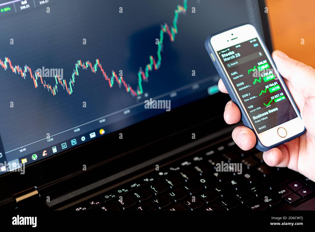Hands of Investor analizzare gli investimenti del mercato azionario con dashboard finanziario e indicatori chiave delle prestazioni sugli schermi di smartphone e computer Foto Stock