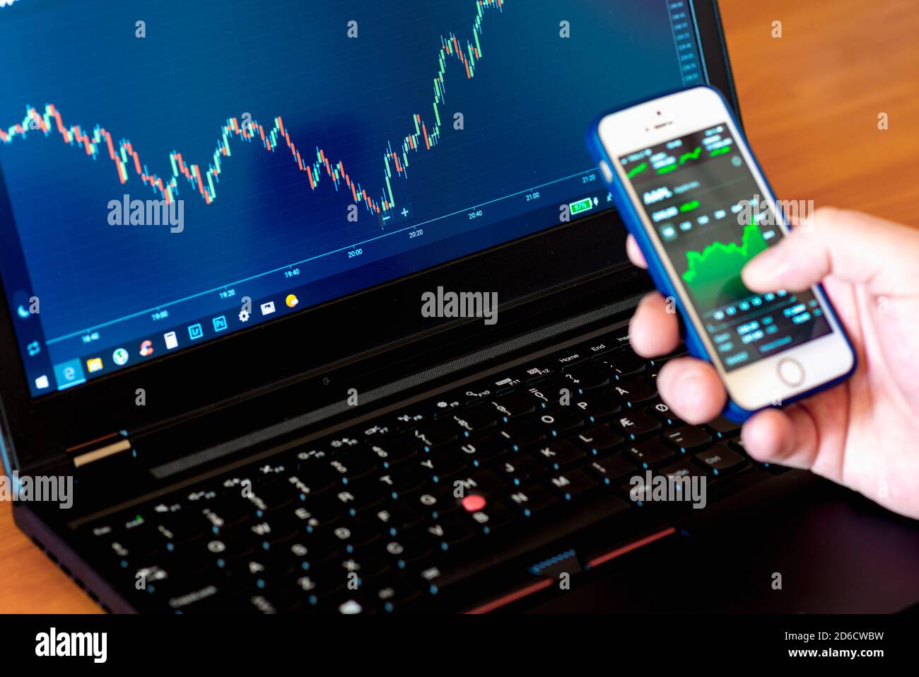 Hands of Investor analizzare gli investimenti del mercato azionario con dashboard finanziario e indicatori chiave delle prestazioni sugli schermi di smartphone e computer Foto Stock