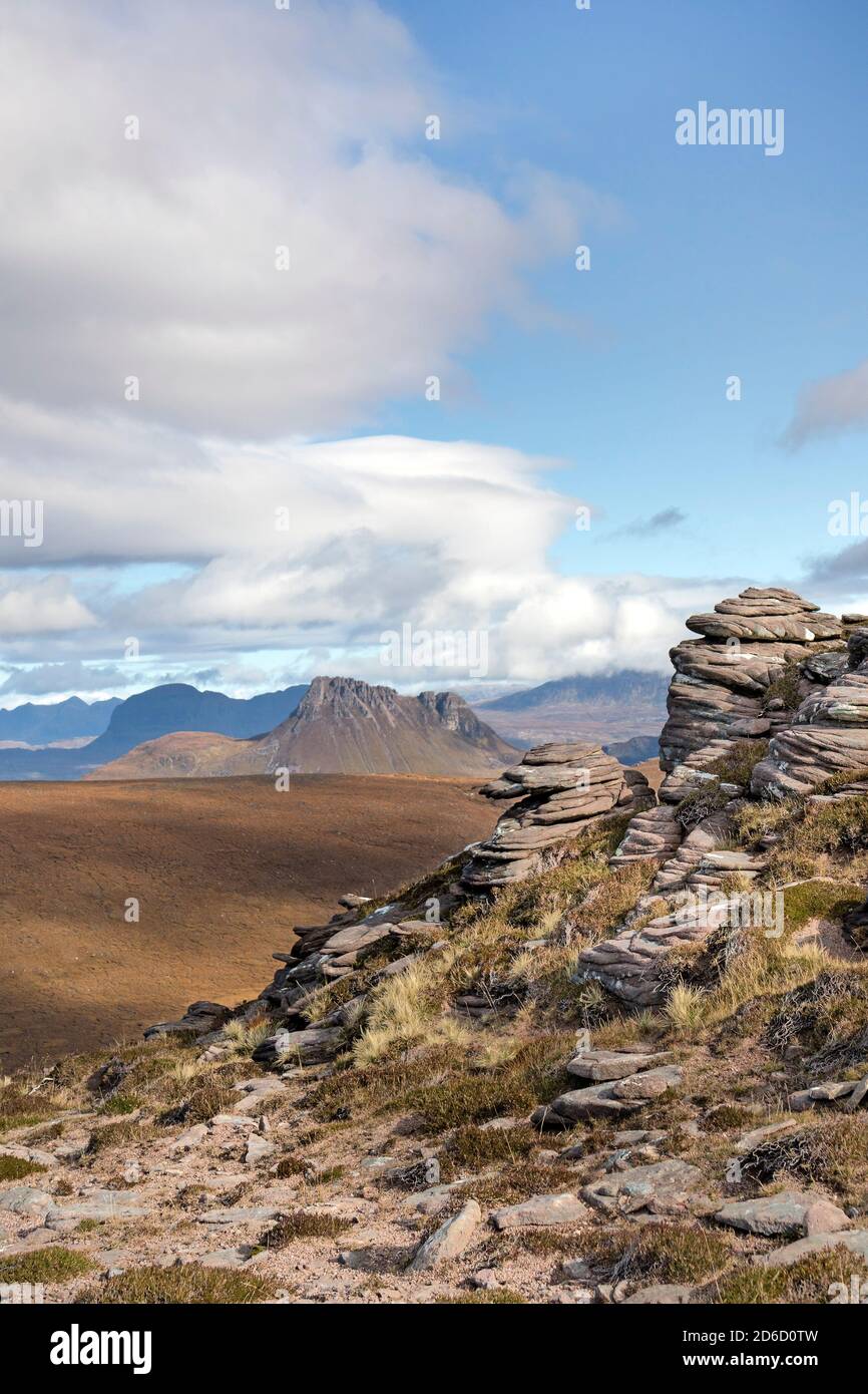 Le formazioni rocciose di granito intemperie e la vista verso Stac Pollaidh da Cairn Conmheall, la penisola di Coigach, le Highlands nordoccidentali della Scozia, Regno Unito Foto Stock