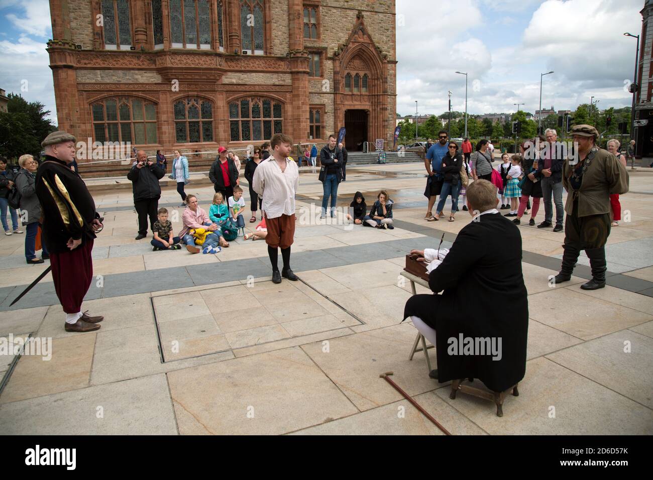 18.07.2019, Derry, Irlanda del Nord, Regno Unito - gli attori dilettanti mostrano ai turisti come potrebbe essere apparsa una causa di corte nel Medioevo. Nella Foto Stock