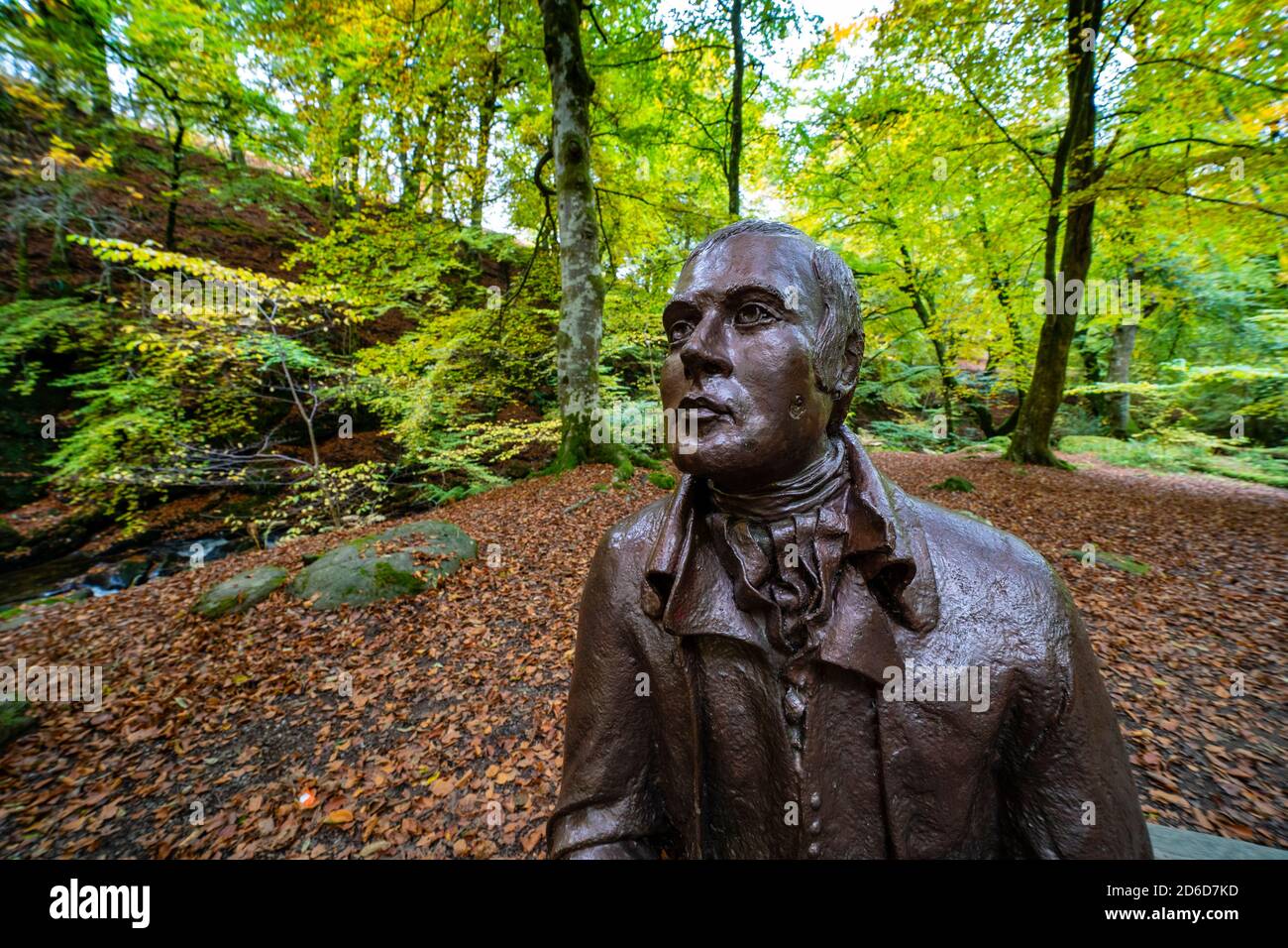 Aberfeldy, Scozia, Regno Unito. 16 ottobre 2020. Colori autunnali lungo il sentiero boschivo e il torrente agli Birks of Aberfeldy nel Perthshire. Nella foto; scultura di Robert Burns gode di sedersi tra i boschi. Iain Masterton/Alamy Live News Foto Stock