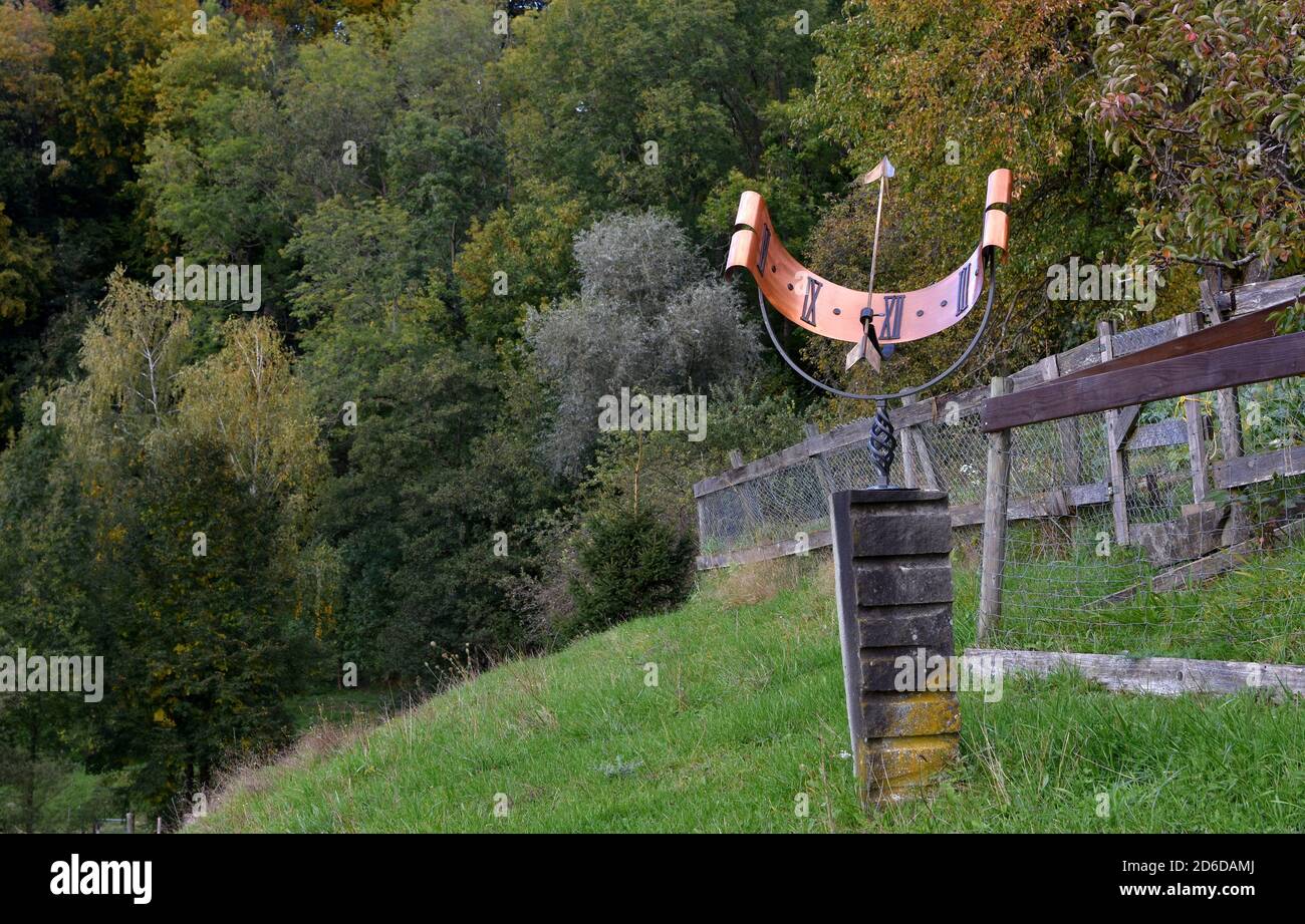 Un orologio solare installato su una collina soleggiata a Weinfelden in Svizzera. È costituito da un sottile rettangolo metallico a forma di semicerchio. Foto Stock