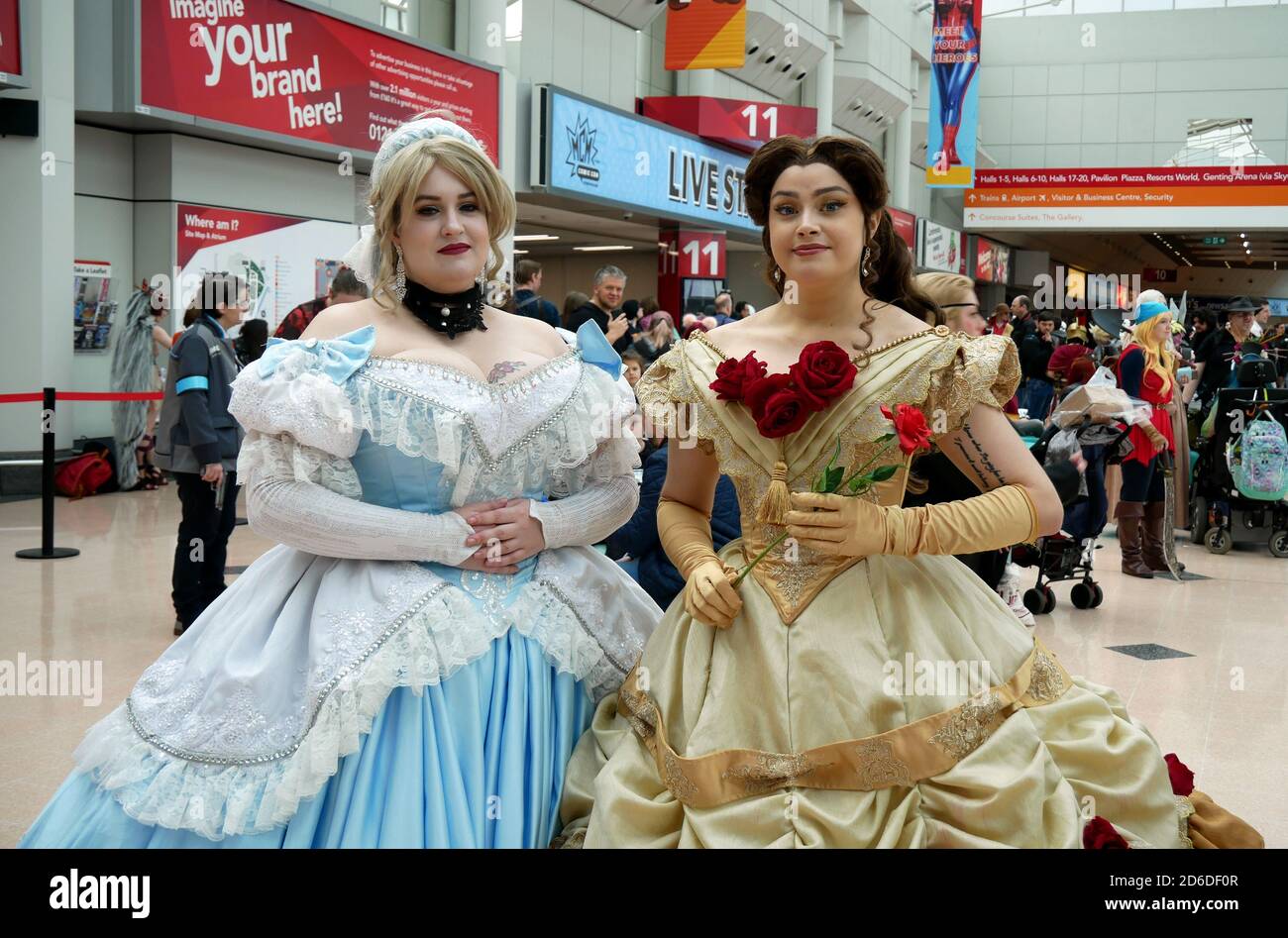 Cosplayer vestiti come Cenerentola e Belle durante il MCM Comic Con tenuto  al NEC Birmingham Foto stock - Alamy