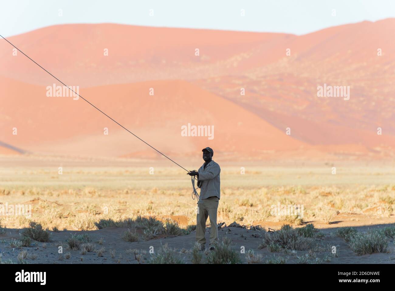 Un giro in mongolfiera in Namibia. L'equipaggio africano di terra fissa la mongolfiera dopo l'atterraggio Foto Stock